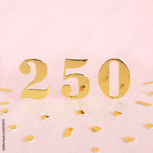 The number 250 is gold numbers on a pink background and golden confetti. Space for text..
