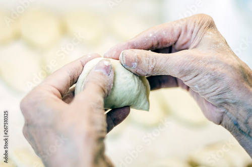 Woman hand making tasty fried patties or pies in kitchen.