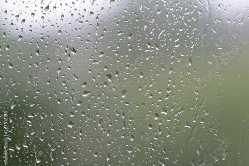 Raindrops on window glass during the rain close up. Natural background