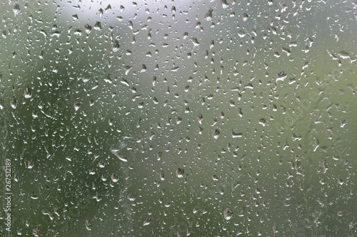 Raindrops on window glass during the rain close up. Natural background