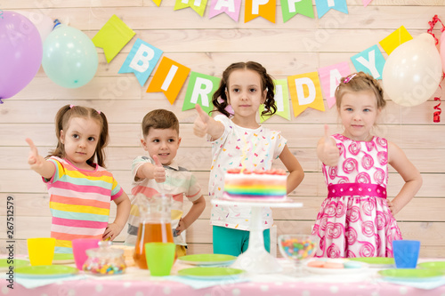 Children celebrating birthday party. Happy kids showing thumbs up
