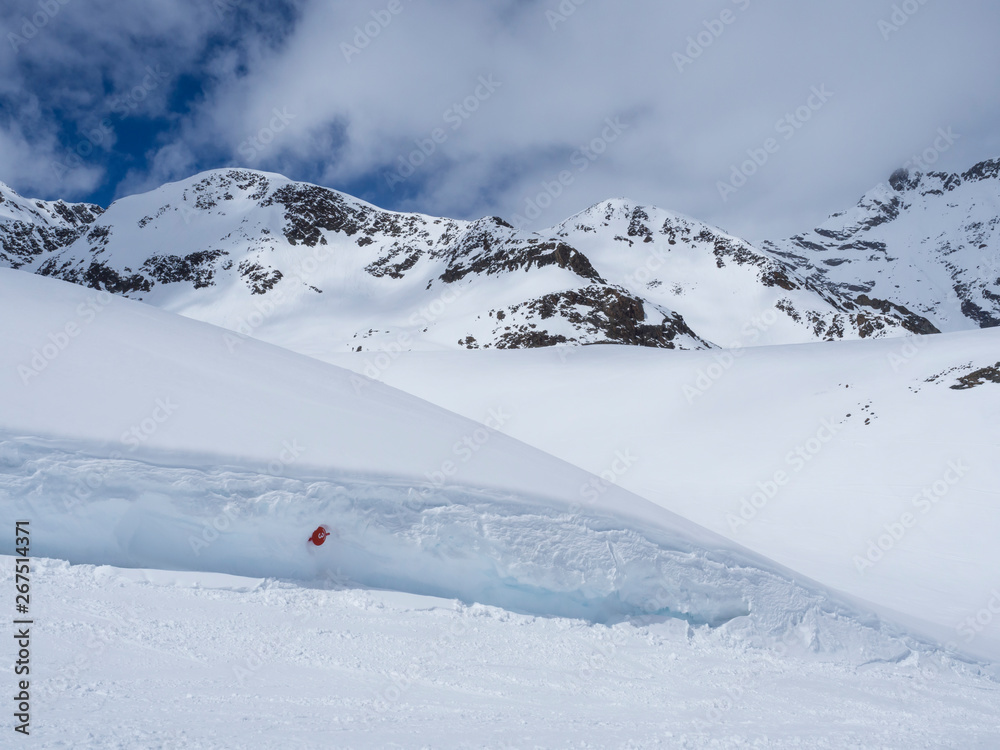Winter landscape with empty red piste sign, snow covered mountain slopes, spring sunny day at ski resort Stubai Gletscher, Stubaital, Tyrol, Austrian Alps.