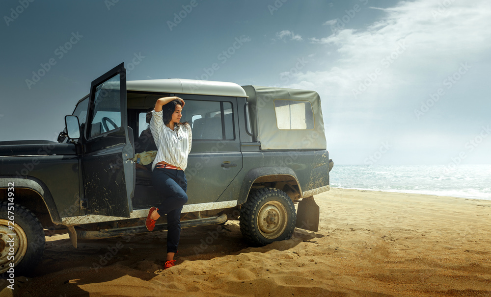 Attractive Young Woman Traveler Enjoying The Sea View, Leaning Back On a Classic Car SUV