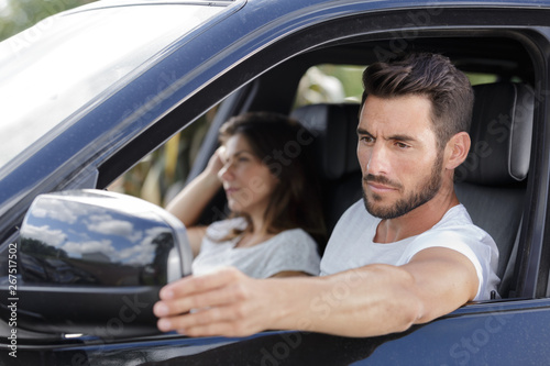 couple in car man adjusting wing mirror