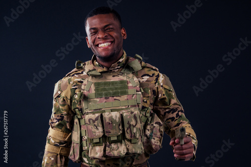 american man in camouflage suit aiming with a pistol