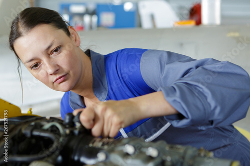 a mechanic woman working on car in his shop