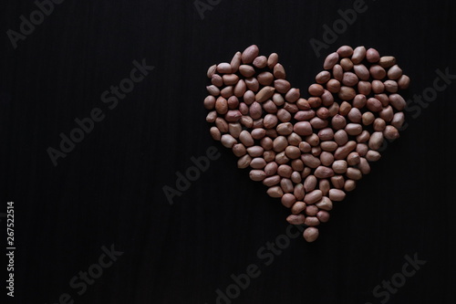 set of raw peanuts making design on a dark wooden table