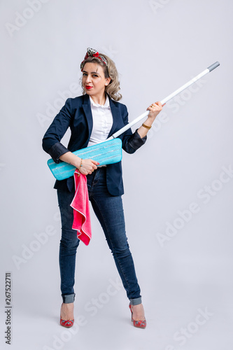 Model in white shirt, blue jacket, jeans with white belt, with pink cloth and mop in hands isolated on white background. photo