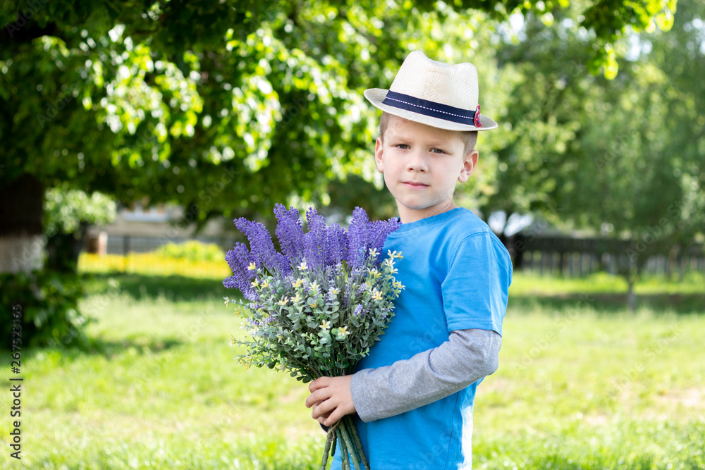little boy posing with a bouquet of flowers in the garden little boy posing with a bouquet of flowers in the garden