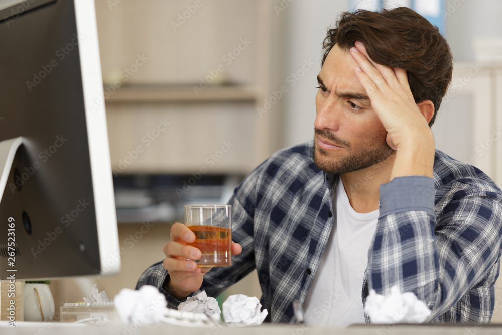 depressed man sitting in office with glass of whisky depressed man sitting in office with glass of whisky