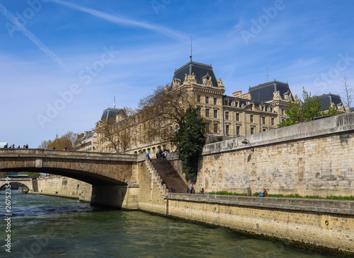 Paris / France - April 06 2019: Bridge across Seine River and beautiful historic buildings of Paris