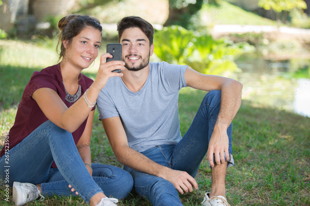 young couple taking selfie in the park young couple taking selfie in the park