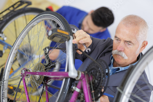 a senior man fixing bike