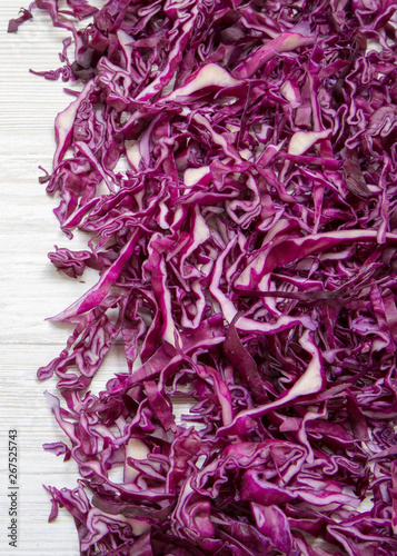 Chopped red cabbage on a white wooden background, close-up. Top view, from above, overhead.