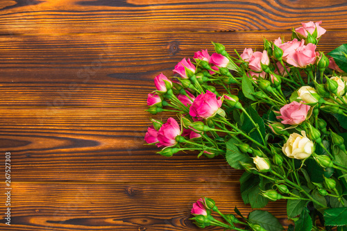 bouquet of small colored roses on a wooden background - Image