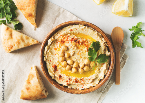 Papier peint Hummus dip with chickpea, pita  and parsley in wooden plate on white background