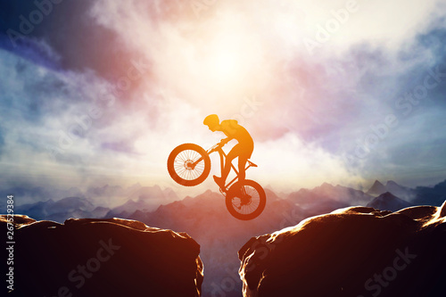 Man jumping with bike between two high mountains