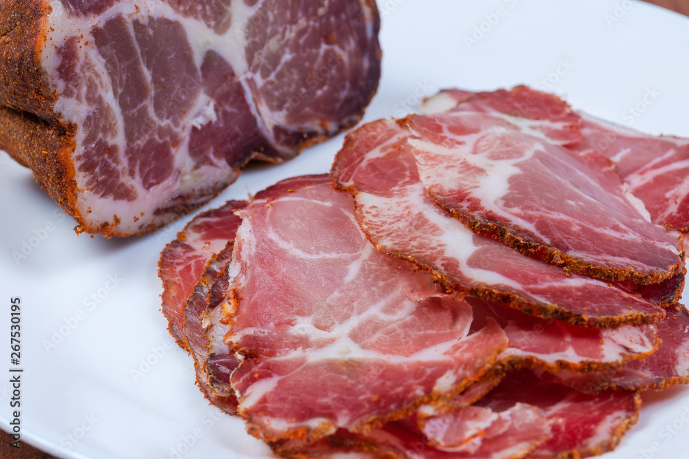 Partly sliced dried pork neck close-up at selective focus Partly sliced dried pork neck close-up at selective focus