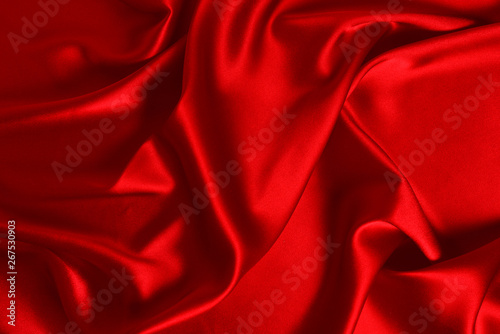 Red silk or satin luxury fabric texture can use as abstract background. Top view.