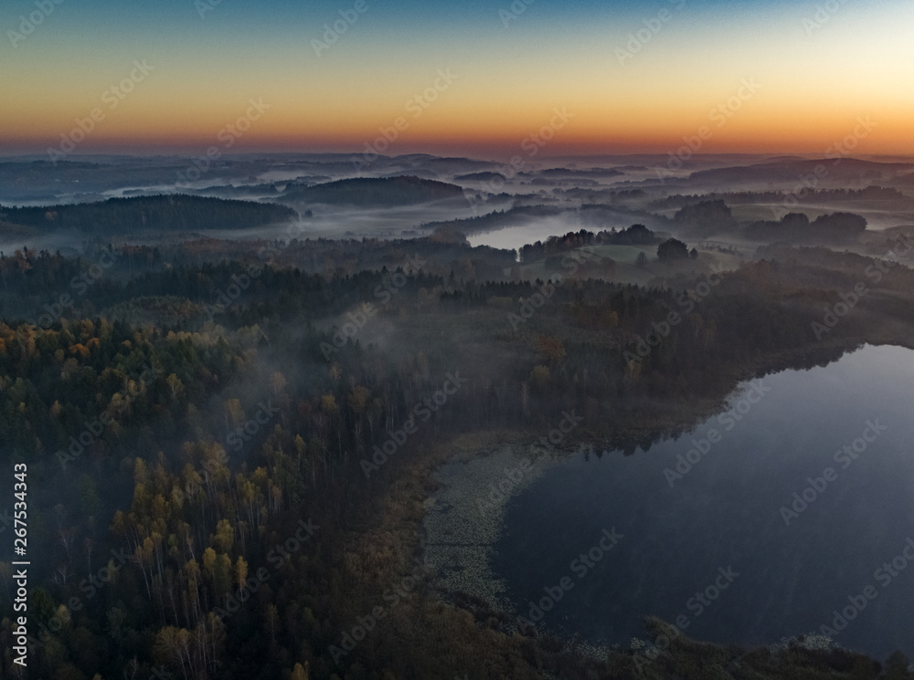 Foggy sunrise over beautiful lakes and forests - drone view