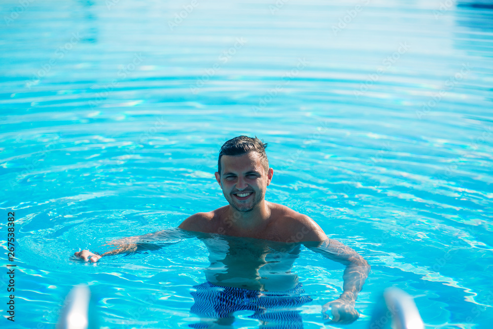 Handsome man in swimming pool. summer day. Resort