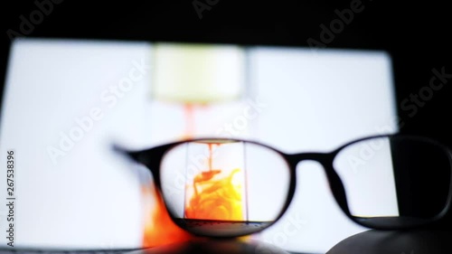 video footage of red food color ink drop from oil into water in clear  test tube through nearsighted eye glasses, close up, full high definition resolution, thirty frame per second, slow-motion