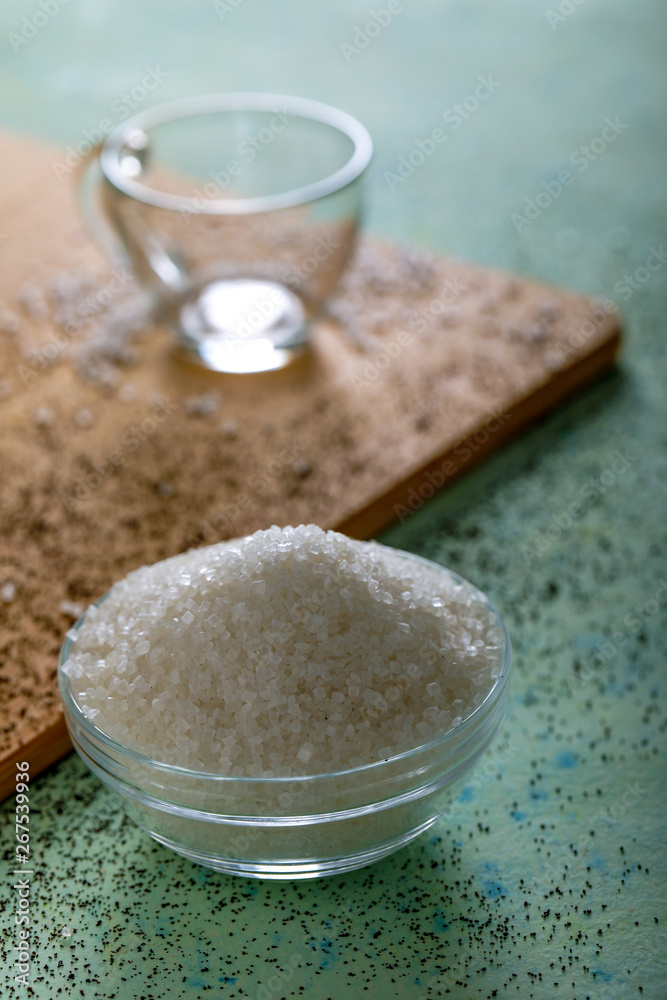 Sugar in glass bowl on wooden background Sugar in glass bowl on wooden background