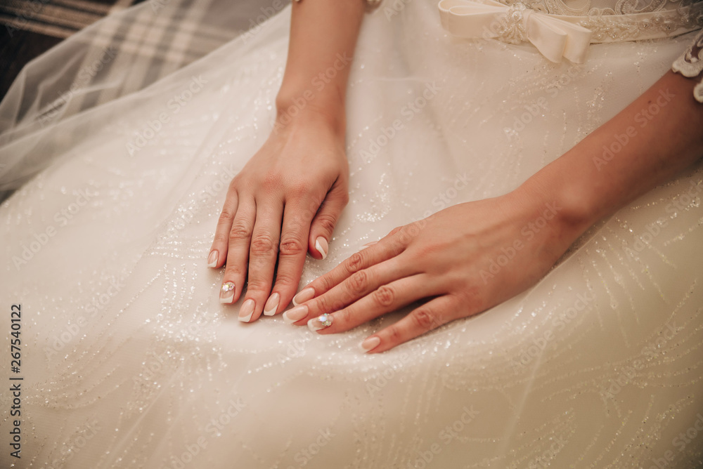 young bride put her hands on her wedding dress sitting on a chair young bride put her hands on her wedding dress sitting on a chair
