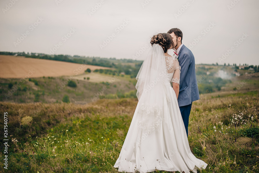 young bride and groom hugging in the field