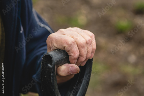 an old man s hand holds a shovel handle