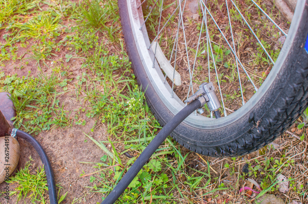 Foto de Inflating the tire of a bicycle. Bicyclist pumping air into the