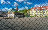 Blick durch einen Maschendrahtzaun auf einen Schulhof