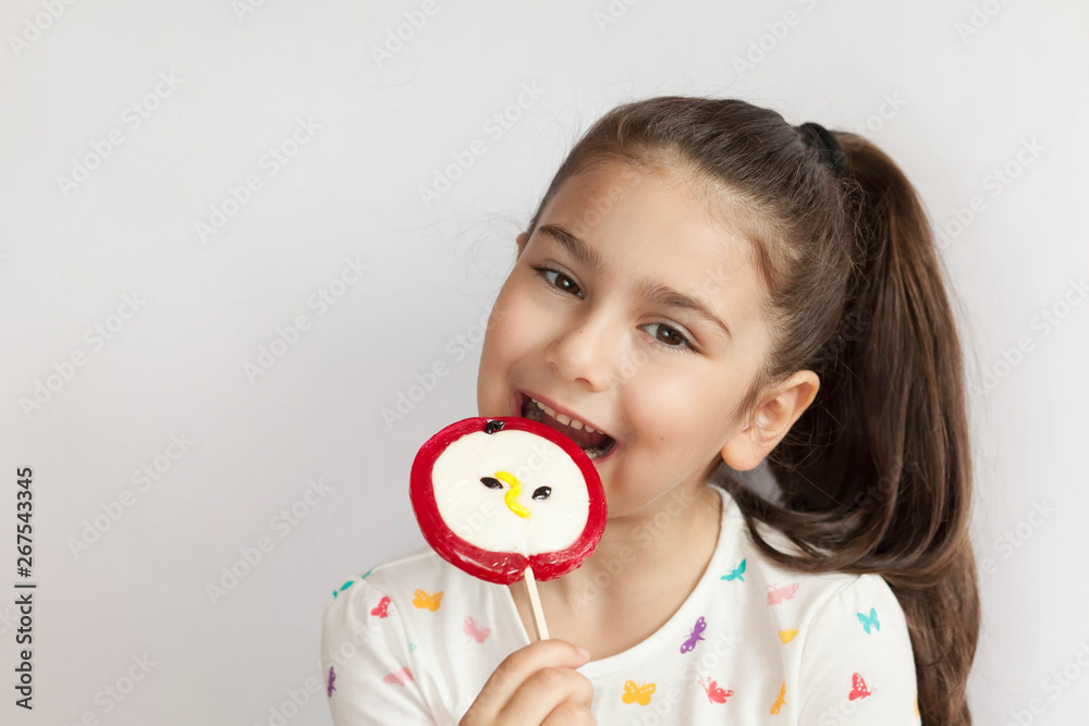 Beautiful cute little child girl eating big lollipop