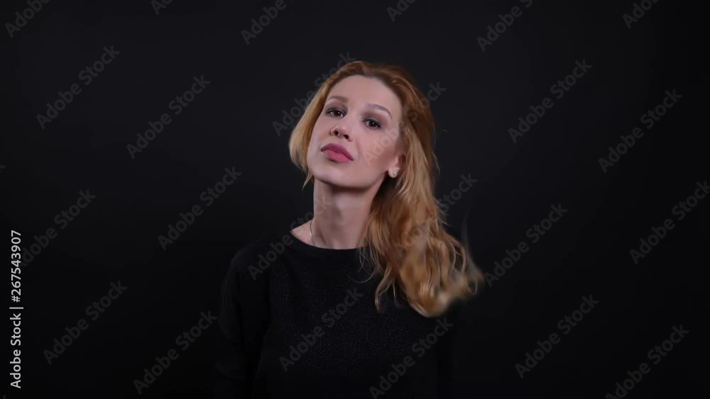 Closeup portrait of adult attractive redhead female smiling seductively looking at camera with background isolated on black Closeup portrait of adult attractive redhead female smiling seductively looking at camera with background isolated on black