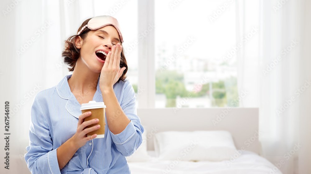 people and bedtime concept - happy young woman in pajama and eye sleeping mask with takeaway paper cup of coffee yawning over background people and bedtime concept - happy young woman in pajama and eye sleeping mask with takeaway paper cup of coffee yawning over background