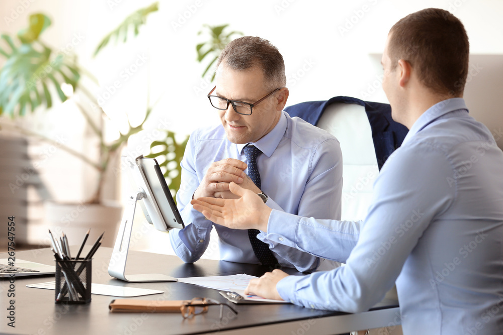 Fototapeta premium Handsome mature businessman with colleague working in office