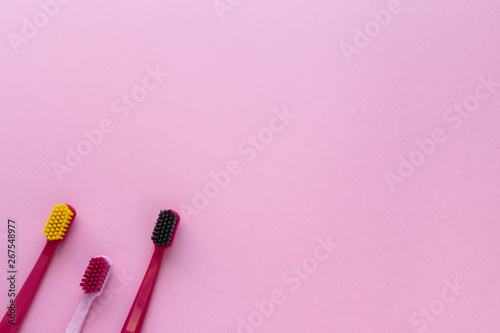 Dental hygiene - tooth brushes flat lay, top view, copy space, pink background