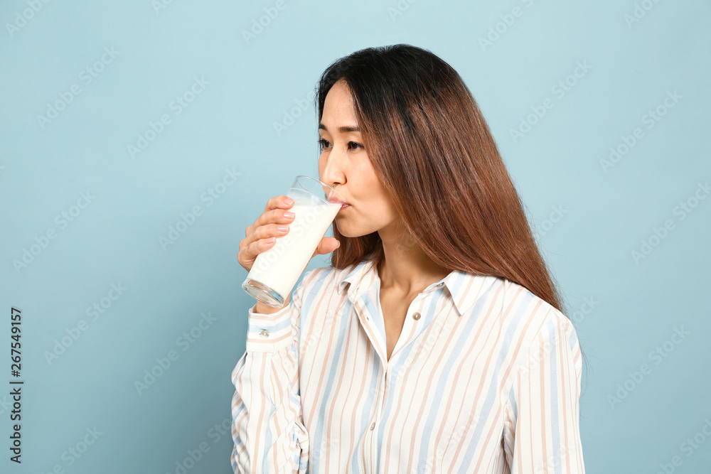 Asian woman drinking milk on color background Asian woman drinking milk on color background