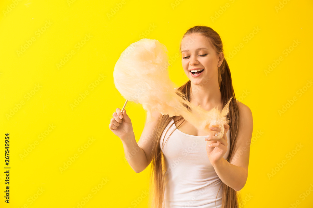 Beautiful woman with cotton candy on color background Beautiful woman with cotton candy on color background