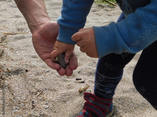  parent and child on the beach. hands macro