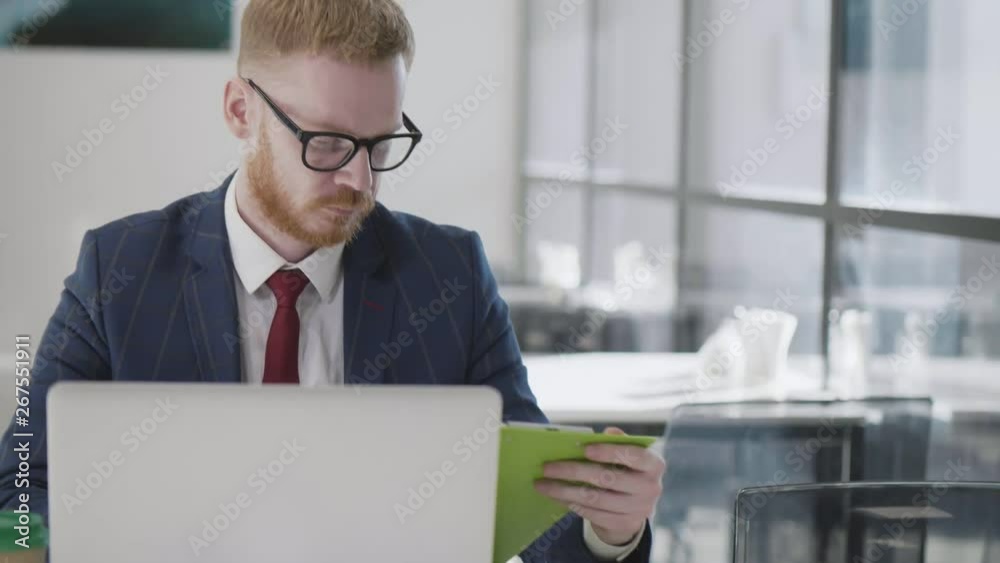 Serious young employee looking at laptop Serious young employee looking at laptop
