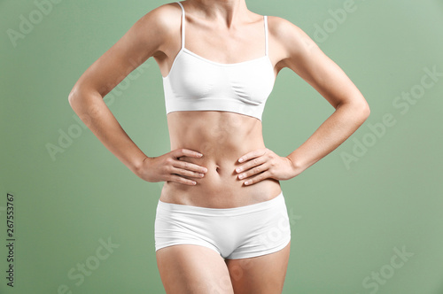 Beautiful young woman in underwear on color background. Plastic surgery concept © Pixel-Shot
