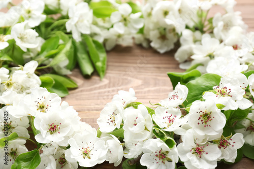 Beautiful flowers and leaves on wooden table, closeup