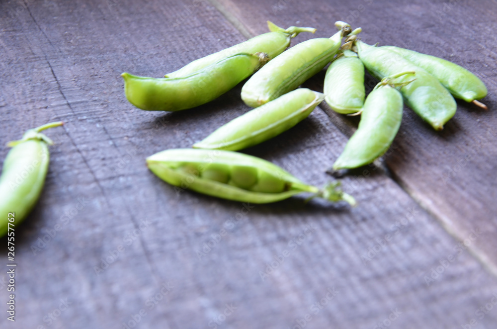 fresh green peas, just harvest. close up view of opened pod. spring vegetable up view on the wooden background fresh green peas, just harvest. close up view of opened pod. spring vegetable up view on the wooden background