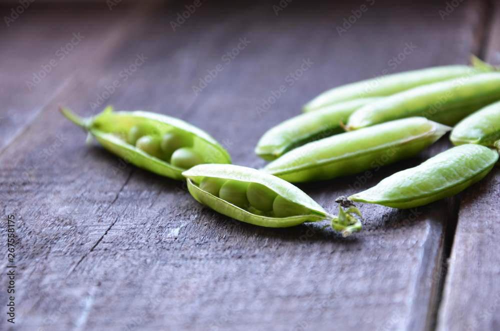 fresh green peas, just harvest. close up view of opened pod. spring vegetable up view on the wooden background fresh green peas, just harvest. close up view of opened pod. spring vegetable up view on the wooden background