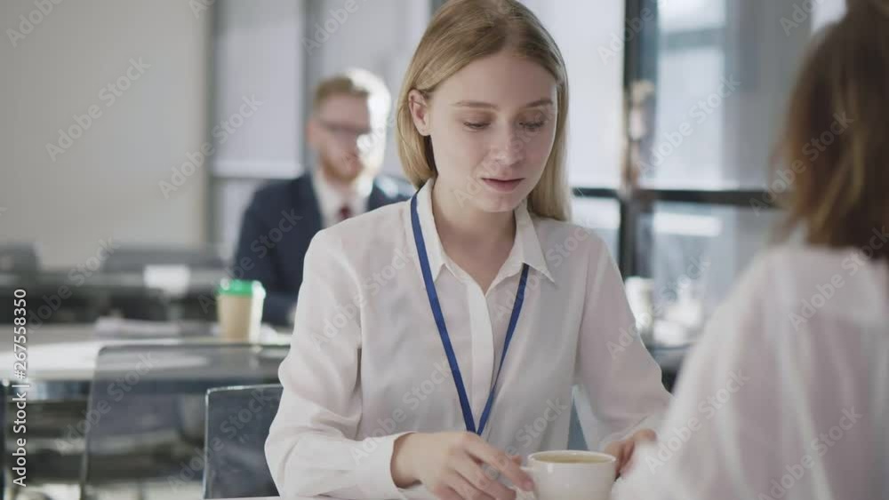 Coffee break. Two female employees sitting at the table. Coffee break. Two female employees sitting at the table.