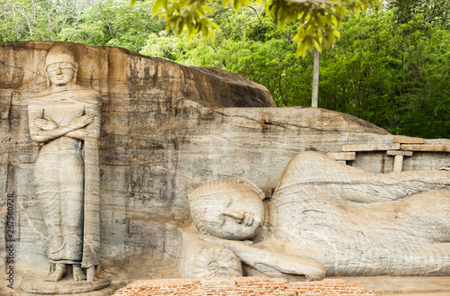 Obraz na płótnie Beautiful statue of the Reclining Buddha and Monk Ananda carved in stone. The Gal Vihara also known as Gal Viharaya is a rock temple situated in the ancient city of Polonnaruwa, Sri Lanka. w salonie