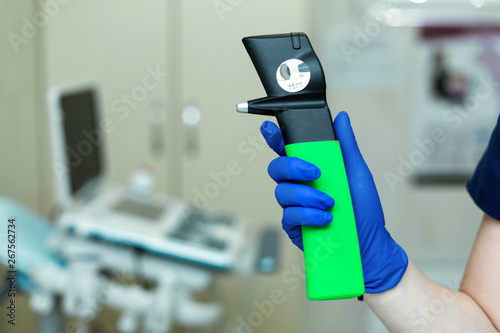 Professional equipment ophthalmologist tonometer..Doctor vet holds in his hand with a glove veterinary tonometer..Blurred background photo