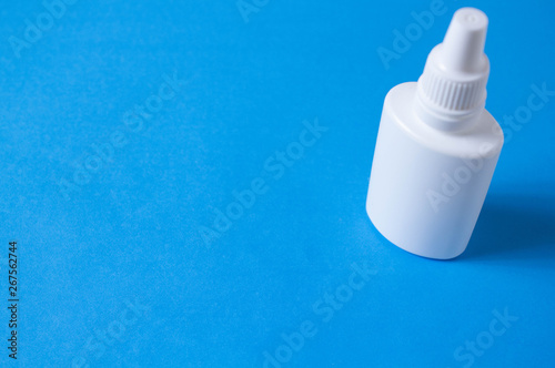 nasal drops bottle isolated on blue background