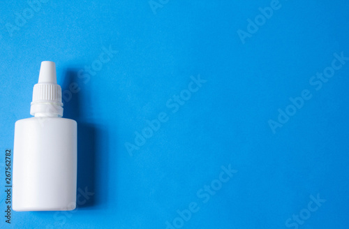 nasal drops bottle isolated on blue background